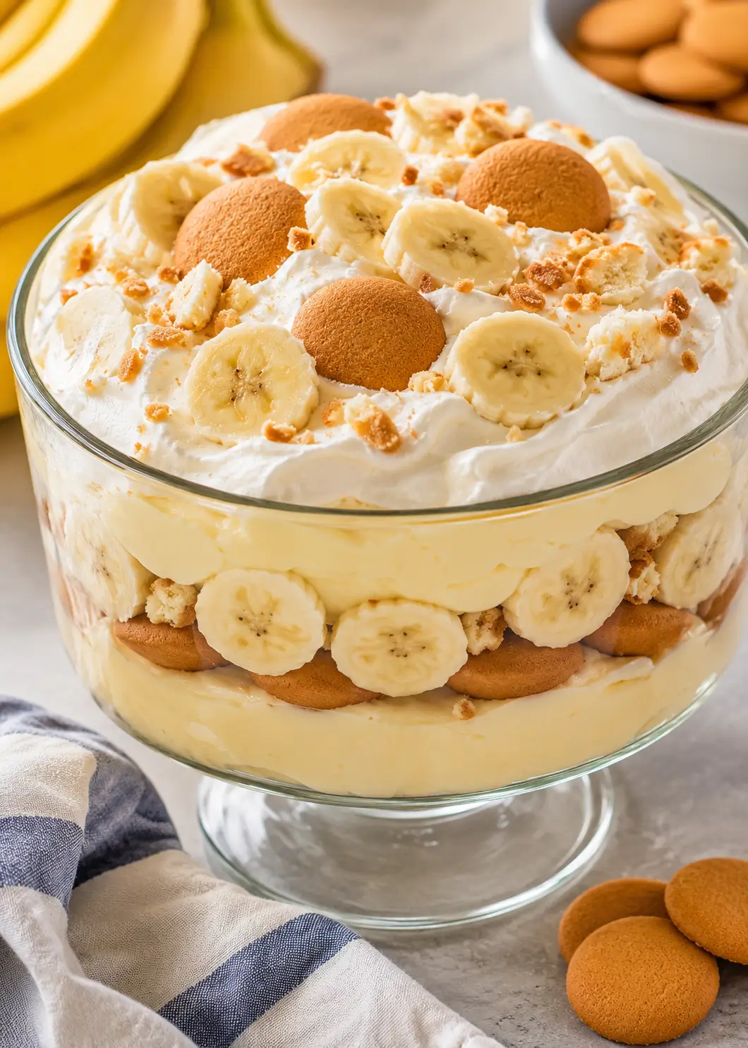 Creamy banana pudding in a glass dish topped with whipped cream and vanilla wafers.