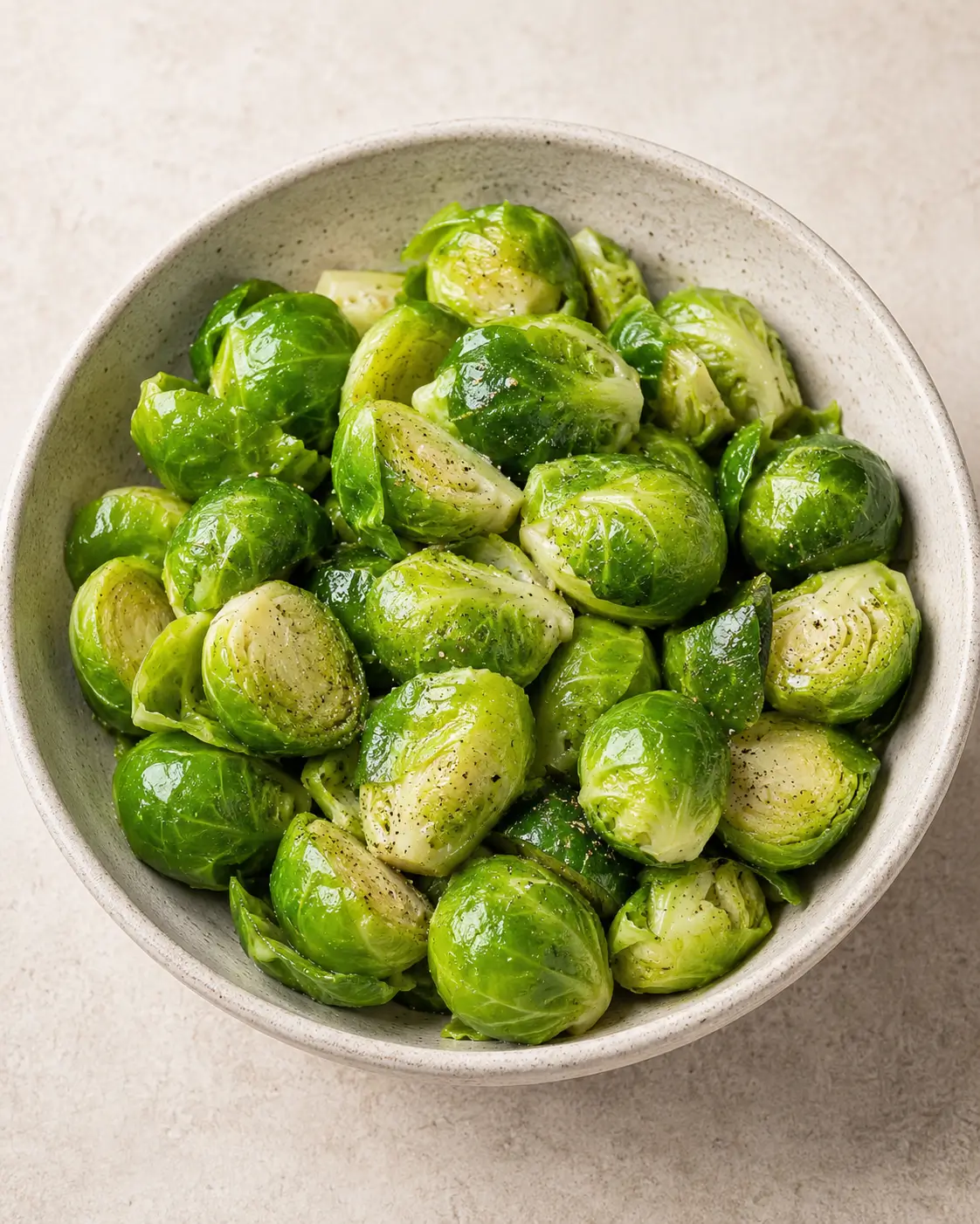 Tender buttery Brussels sprouts in a simple white serving bowl.
